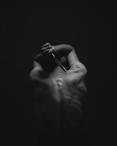 Man håller detaljrik kniv över huvudet